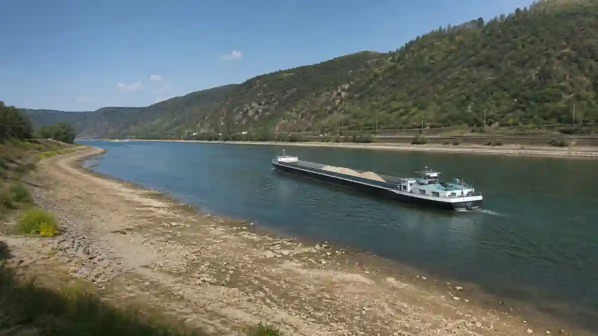 低水位で川岸が広く見えるライン川を積載量を抑えた貨物船が航行する様子