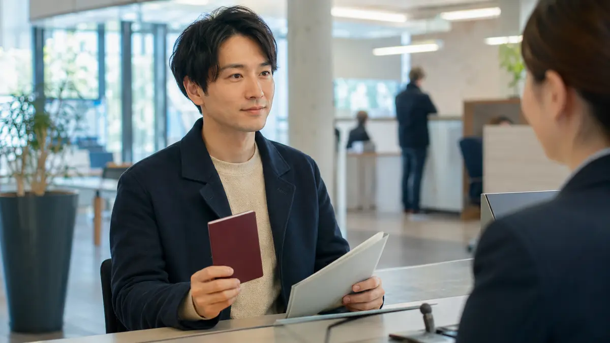 ドイツの滞在許可申請に必要なパスポート、書類フォルダー、予約画面を準備する様子